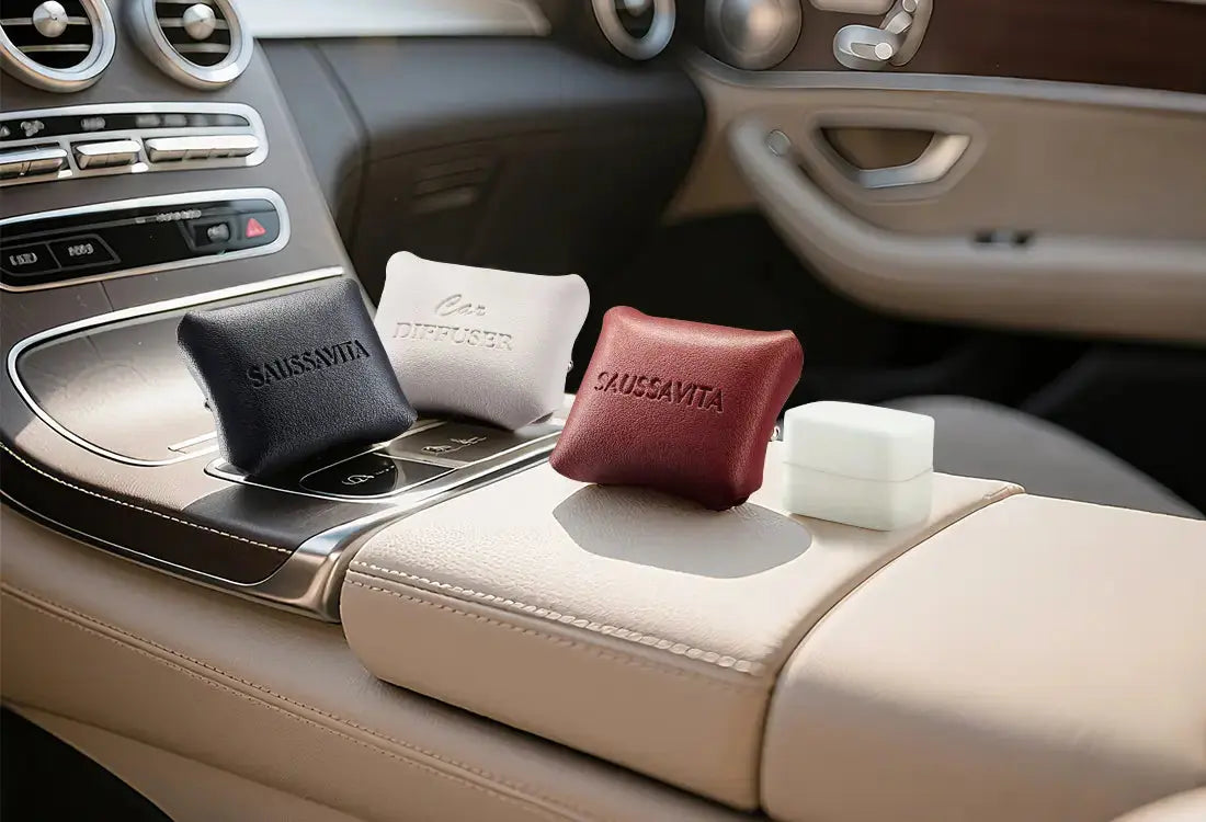 SAUSSAVITA alcohol-free car diffuser pouches in black/white/red on luxury car console